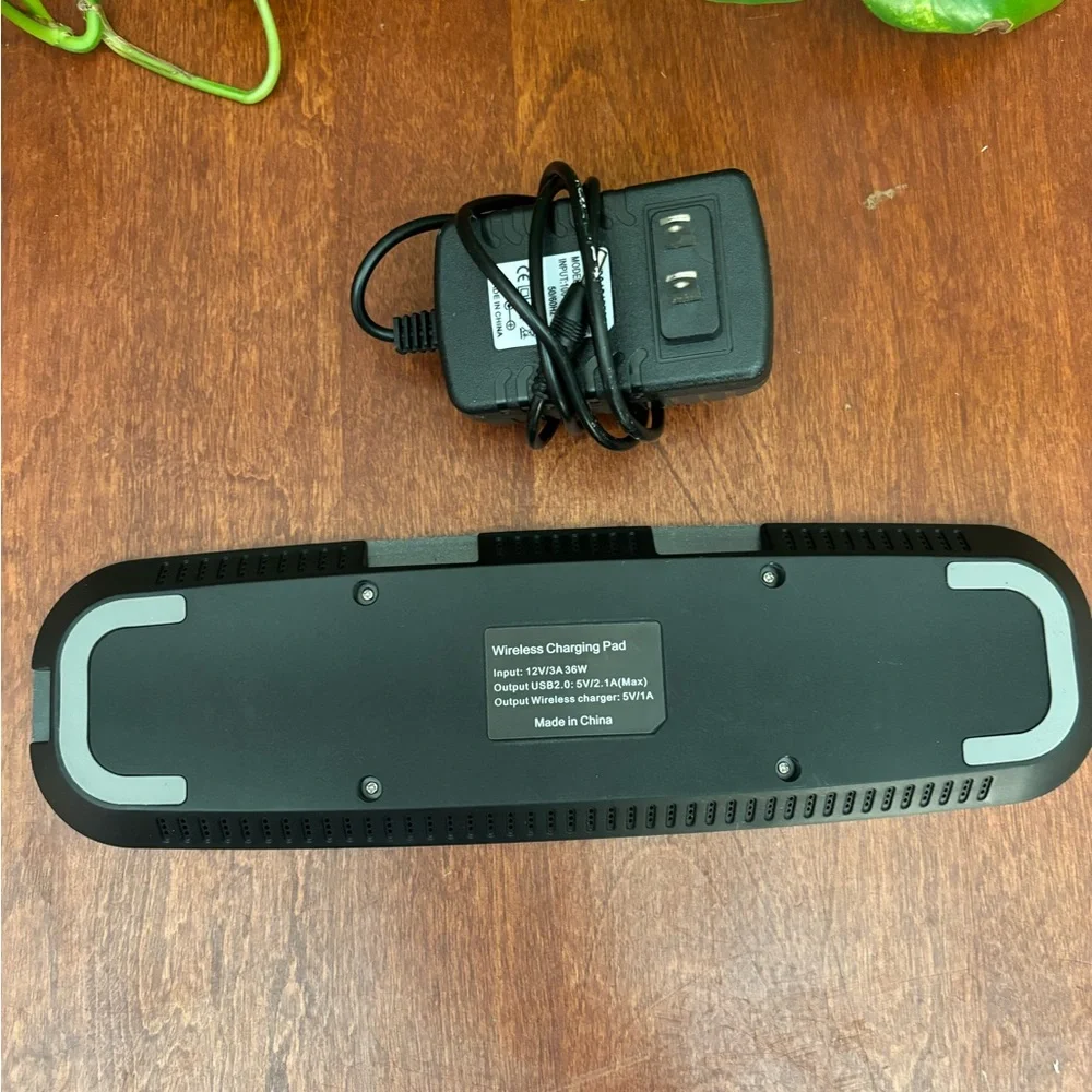 Wireless charger pad with 2 USB ports and power cord.